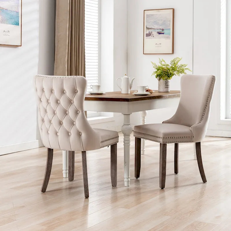 Silla de comedor tapizada de terciopelo con respaldo alado, capitoné y remate de tachuelas